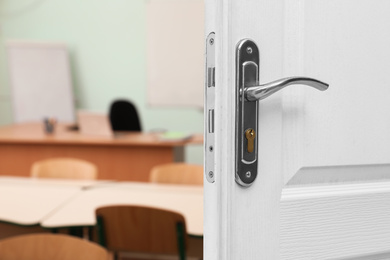 Wooden door open into modern empty classroom