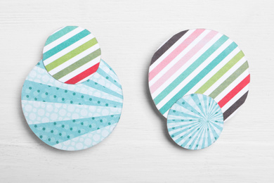 Big and small colorful paper circles on white wooden background, flat lay. Pareto principle concept