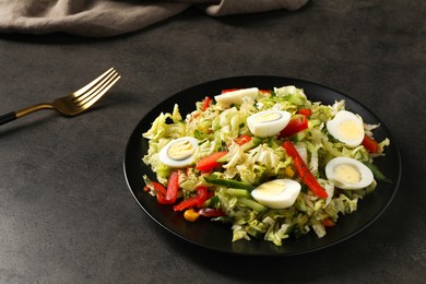 Delicious salad with Chinese cabbage and quail eggs served on black table