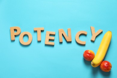 Word Potency made of wooden letters near banana and nectarines symbolizing male genitals on light blue background, flat lay