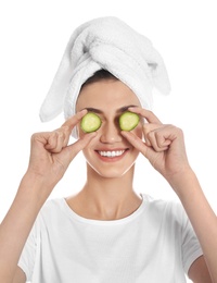 Photo of Happy young woman with towel holding cucumber slices on white background. Organic face mask