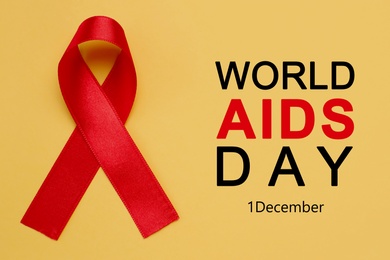 Image of World AIDS Day poster. Red awareness ribbon and text on yellow background