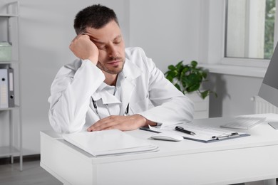 Exhausted doctor sleeping at workplace in hospital