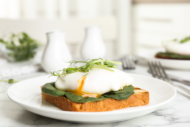 Delicious poached egg sandwich served on white marble table
