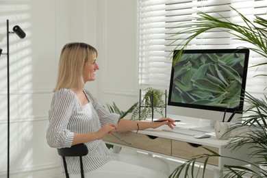 Woman working on computer at table in room. Interior design