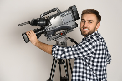 Operator with professional video camera on white background