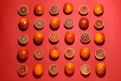 Many ripe sicilian oranges on red background, flat lay
