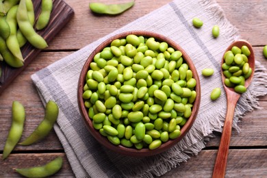 Photo of Delicious edamame beans on wooden table, flat lay