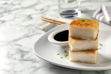 Tasty turnip cake served on white marble table. Space for text