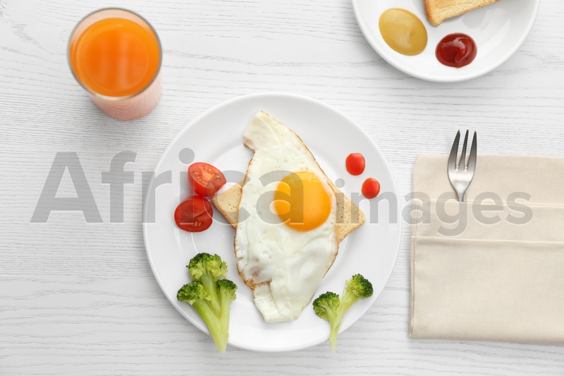 Tasty fried eggs with vegetables and juice on white wooden table, flat lay. Delicious morning meal