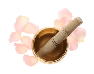 Golden singing bowl with mallet and petals on white background, top view. Sound healing