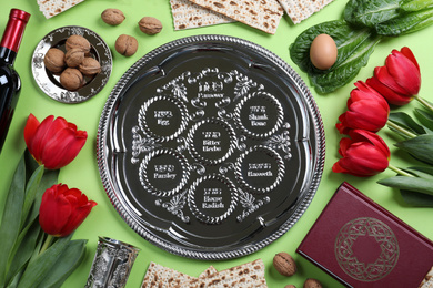 Flat lay composition with symbolic Pesach (Passover Seder) items on light green background