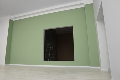 Photo of Empty office room with color walls. Opening for fake window