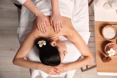 Photo of Beautiful woman receiving back massage in beauty salon, closeup. Top view