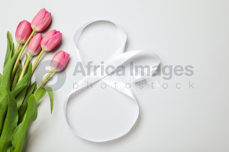 Photo of 8 March greeting card design with tulips and ribbon on light grey background, flat lay. International Women's day