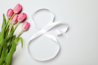 8 March greeting card design with tulips and ribbon on light grey background, flat lay. International Women's day