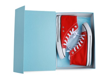 Pair of stylish red shoes in turquoise box on white background, top view