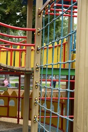 Children's playground with climbing rope net on summer day
