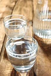 Glass of water on wooden table. Refreshing drink