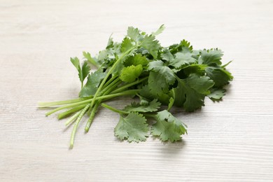 Bunch of fresh aromatic cilantro on white wooden table