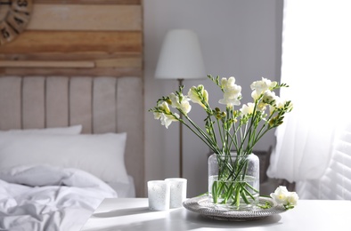 Beautiful spring freesia flowers on table in bedroom