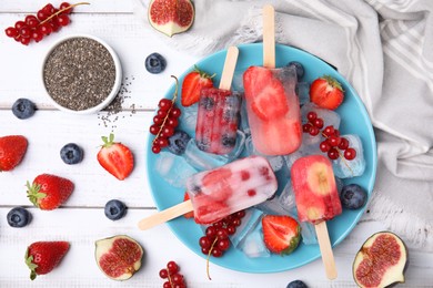 Photo of Flat lay composition with fruit and berry ice pops on white wooden table
