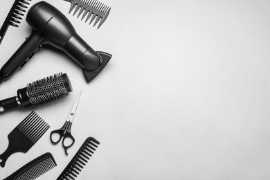 Photo of Flat lay composition of professional hairdresser tools on white background, space for text