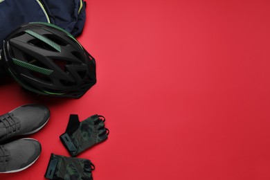 Flat lay composition with different cycling accessories on red background, space for text