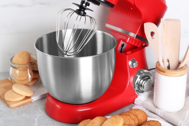 Modern red stand mixer and cookies on light gray marble table