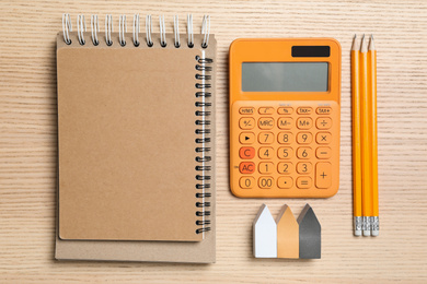 Calculator, notebook, stickers and pencils on wooden table, top view. Tax accounting