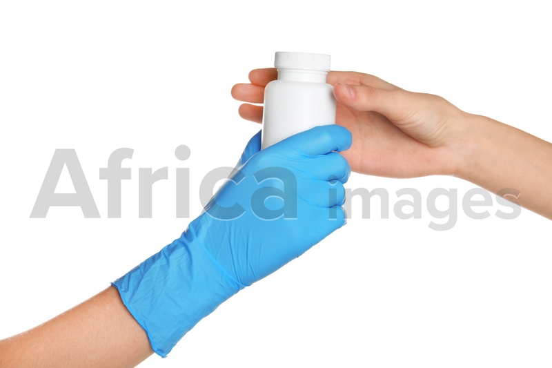 Doctor in medical glove giving bottle of pills to patient on white background