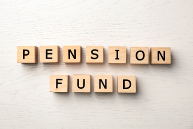 Cubes with words "PENSION FUND" on wooden background