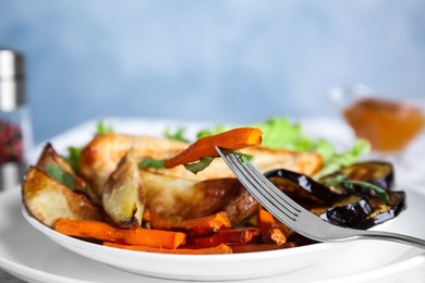 Photo of Delicious cooked vegetables and fork on plate, closeup. Healthy meals from air fryer
