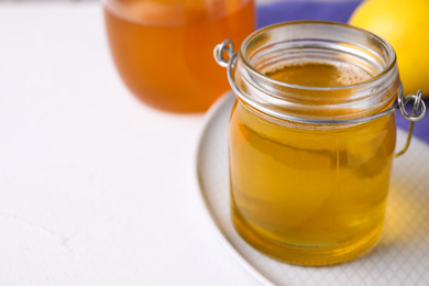 Tasty aromatic honey on white table, closeup