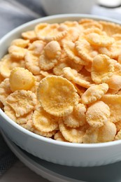 Photo of Bowl of tasty corn flakes on table, closeup