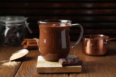 Photo of Cup of delicious hot chocolate on wooden table