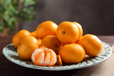 Photo of Fresh tangerines on wooden table. Citrus fruit