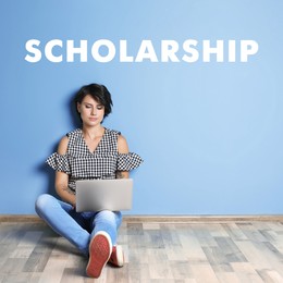 Scholarship concept. Student with laptop sitting on floor near light blue wall