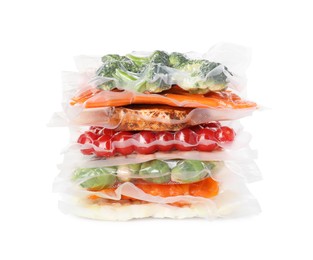 Stack of vacuum packs with different food products on white background