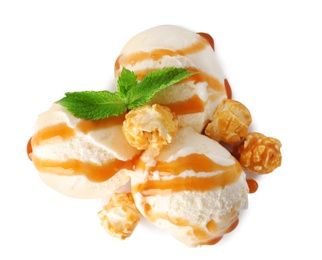 Scoops of delicious ice cream with mint, caramel sauce and popcorn on white background, top view