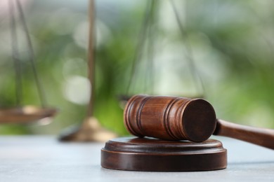 Wooden gavel on grey table against blurred background