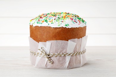 Photo of Traditional Easter cake with sprinkles on white wooden table