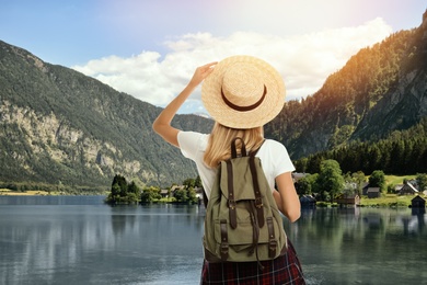 Tourist with travel backpack enjoying mountain landscape during summer vacation trip