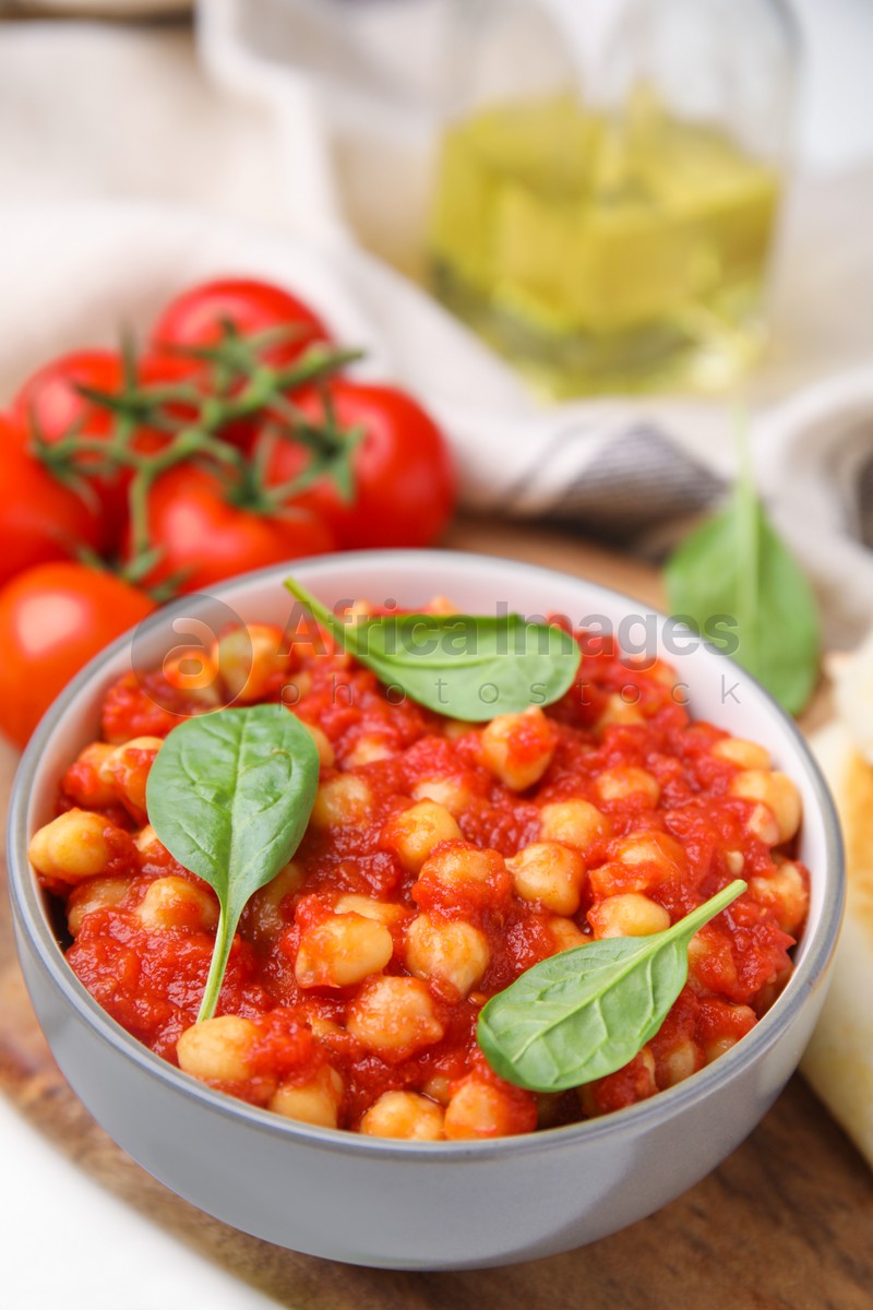 Delicious chickpea curry with basil in bowl, closeup