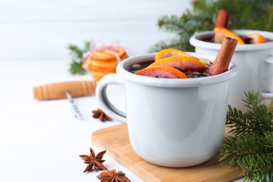 Aromatic mulled wine on white wooden table, closeup