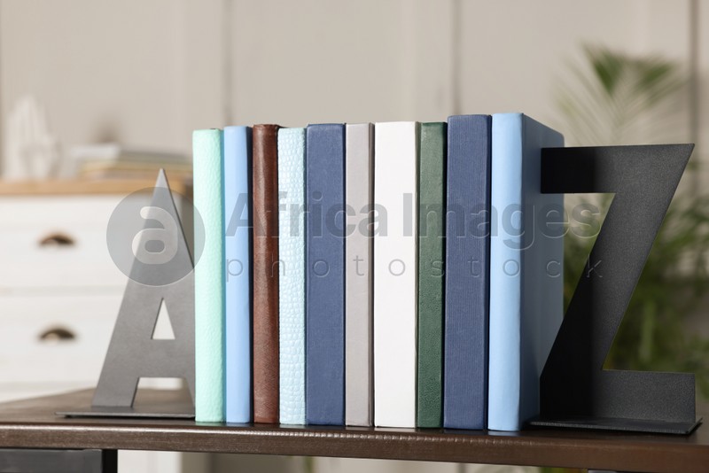 Photo of Minimalist letter bookends with books on shelf indoors