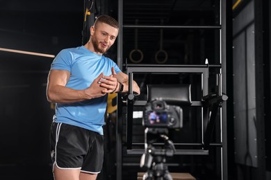Photo of Man recording online training on camera at gym. Fitness coach