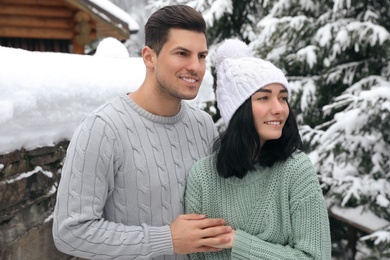 Happy couple in warm sweaters outdoors on winter day