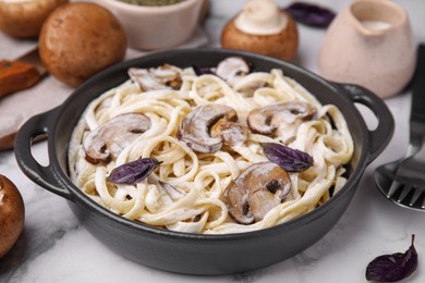 Delicious pasta with mushrooms on white marble table, closeup