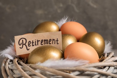 Different eggs and card with word Retirement in nest, closeup. Pension concept
